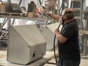 Volunteer Mike Creedon paints components of the interior of the M36 Jackson.